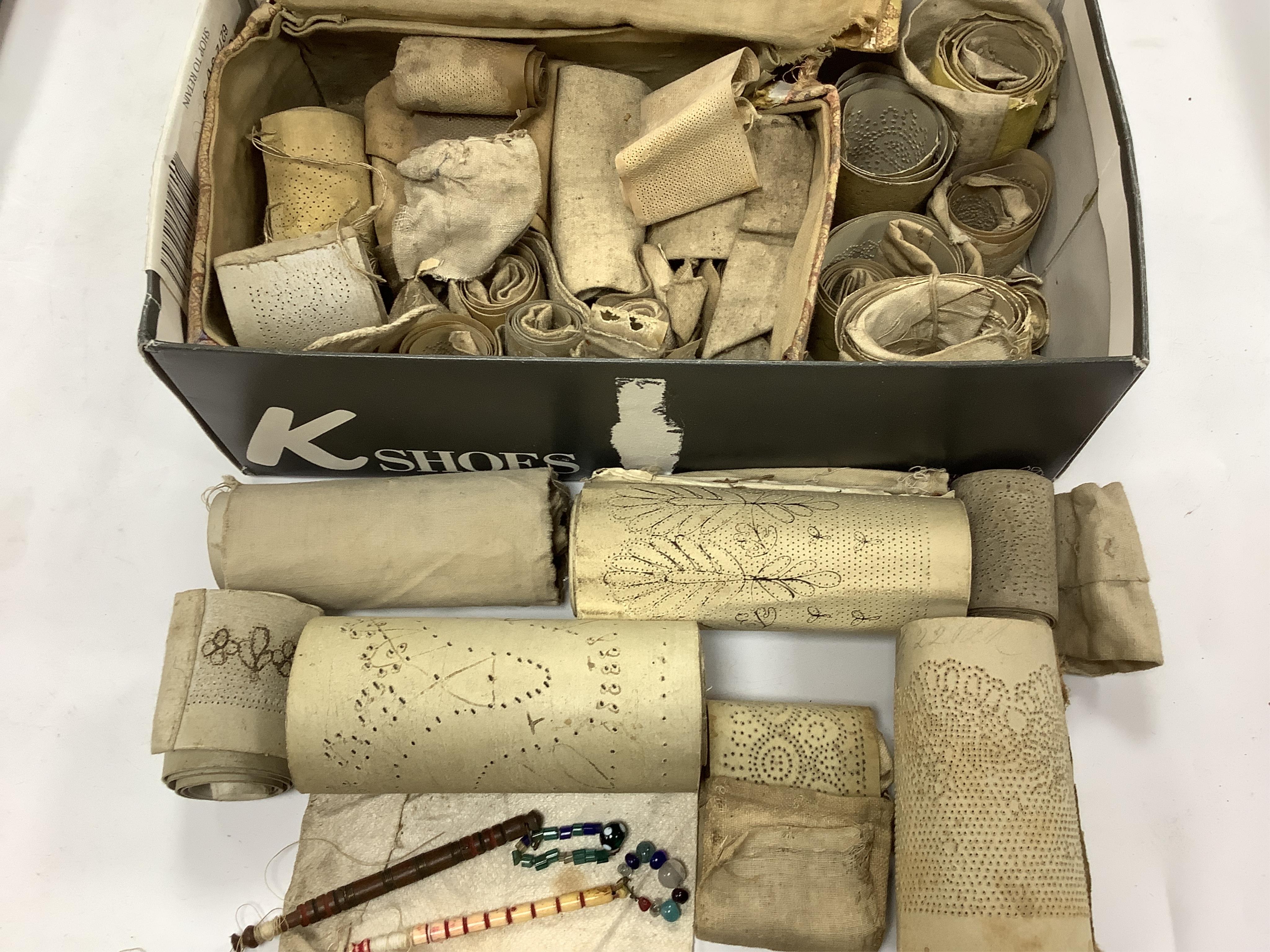A collection of 19th century lace making patterns, a pair of 19th century kid leather and embroidered gloves, a small china doll in costume and an embroidered sash/ribbon - 210cm long, together with a silk woven lace pat
